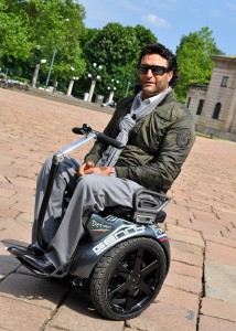 Disabili DOC – Genny Mobility – Paolo Badano in una piazza con una pavimentazione accidentata