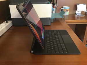 Disabili DOC – L'immagine mostra l'iPad Pro 12,9" 2020 sulla Magic Keyboard, la vista laterale mette il evidenza il frutto del cavo magnetico inserito nella porta USB-C della tastiera