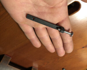 Disabili DOC – La mano di Simone ci mostra una delle due barrette di fissaggio del KeyPhonePad alla scrivania